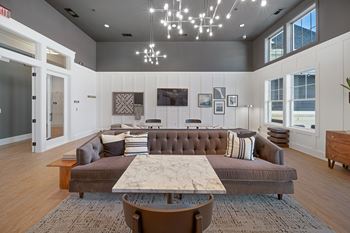 A modern living room with a brown couch and a wooden coffee table.